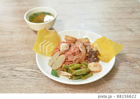 dry Chinese yellow noodles with fish ball and tofu topping crispy squid in red sauce on plate and soup dry Chinese yellow noodles with fish ball and tofu topping crispy squid in red sauce on plate and soup 88156622