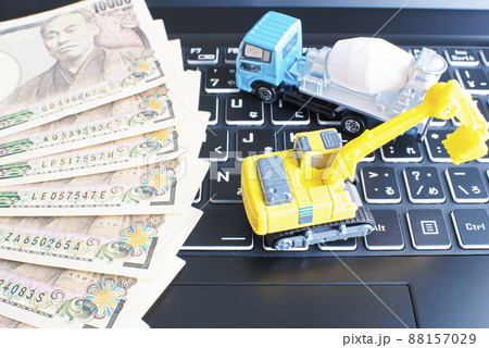 黒色のパソコンキーボードと1万円札とミキサー車とショベルカー 88157029