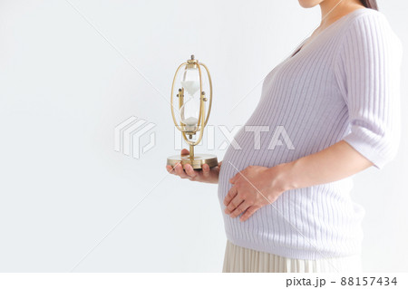 砂時計を持つ妊婦　考える　時間経過　予定日　残り時間　カウントダウン　イメージ 88157434