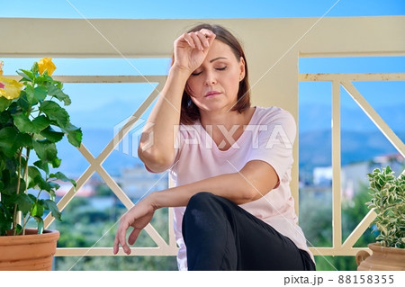Frustrated depressed lonely middle aged woman holding her head with her hands Frustrated depressed lonely middle aged woman holding her head with her hands 88158355