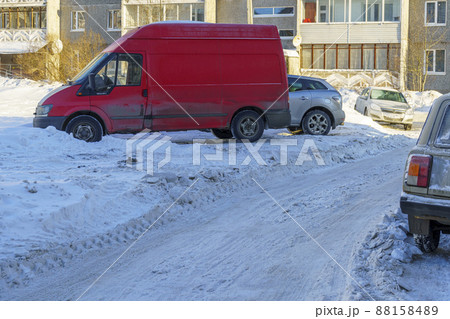 Cars parked in city yard where snow was not removed well in winter Cars parked in city yard where snow was not removed well in winter 88158489