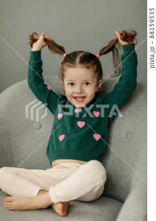 Portrait of a charming little girl with two ponytails, joyful and smiling 88159535