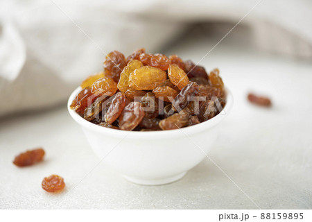 large raisins from black grapes in a white bowl large raisins from black grapes in a white bowl 88159895