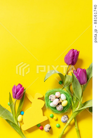 Colorful Easter background. Holiday greeting card with painted eggs, purple tulip. Top view flat lay. Copy space. Colorful Easter background. Holiday greeting card with painted eggs, purple tulip. Top view flat lay. Copy space. 88161740