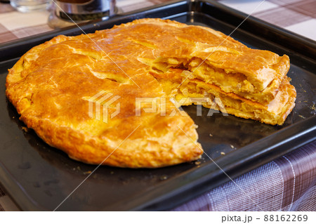 freshly baked domestic ossetian pie on a baking sheet with cutted piece over freshly baked domestic ossetian pie on a baking sheet with cutted piece over 88162269