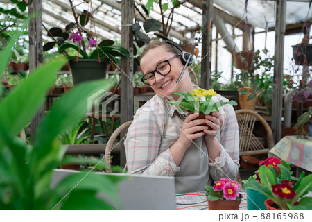 Young woman sells flowers and seedlings via video link on laptop via the Internet. Gardening, sales 88165988