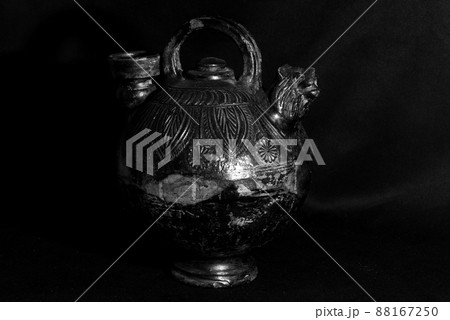 Netherlands, March 2022. Antique black pitcher against a black background. Netherlands, March 2022. Antique black pitcher against a black background. 88167250
