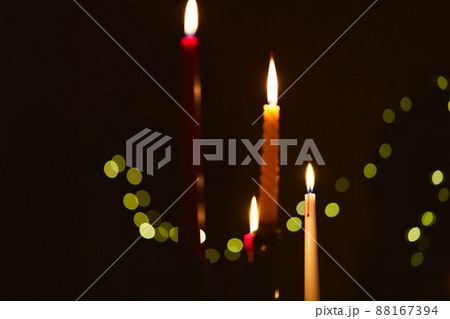 Many candles burn in the dark. The concept of waiting for a holiday and comfort in winter. Front view. Many candles burn in the dark. The concept of waiting for a holiday and comfort in winter. Front view. 88167394