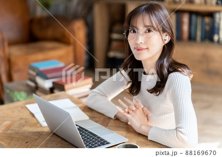 シックな部屋でオンライン会議をする眼鏡の女性 88169670
