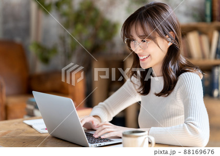 シックな部屋でオンライン会議をする眼鏡の女性 88169676