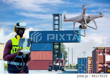 Foreman or worker use remote controller piloting drone at containers port Foreman or worker use remote controller piloting drone at containers port 88173019