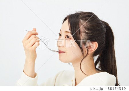 スプーンで食事をする女性　 88174319