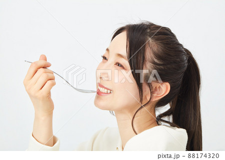 スプーンで食事をする女性　 88174320