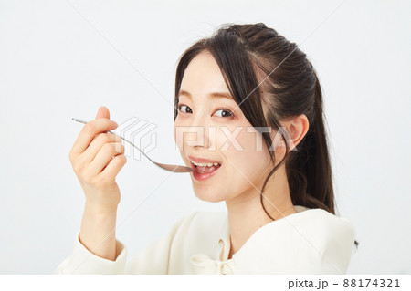 スプーンで食事をする女性　 88174321
