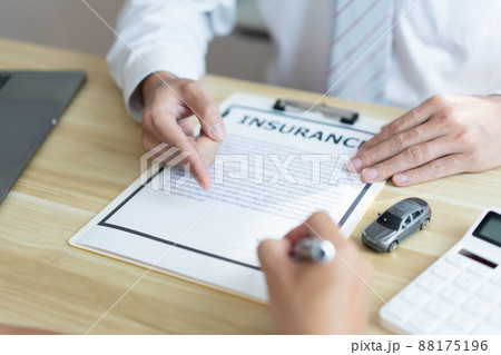Insurance concept the male dealer suggesting his customer to sign the contract of car purchasing 88175196