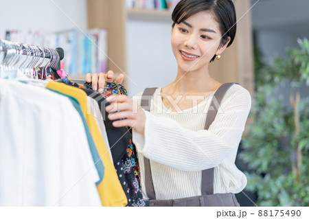 オフィスの衣装ラックから服を選ぶ若いファッションエディター 88175490