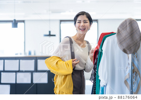 オフィスの衣装ラックから服を選ぶ若い女性ファッションエディター 88176064