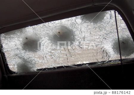 Big crack to windshield of car from fragment military sniper bullet 88176142
