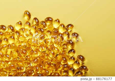 Heap of transparent fish oil capsules on yellow background with free space Heap of transparent fish oil capsules on yellow background with free space 88176177
