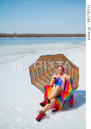 Caucasian woman in a swimsuit sunbathes on the snow in winter. 88178331