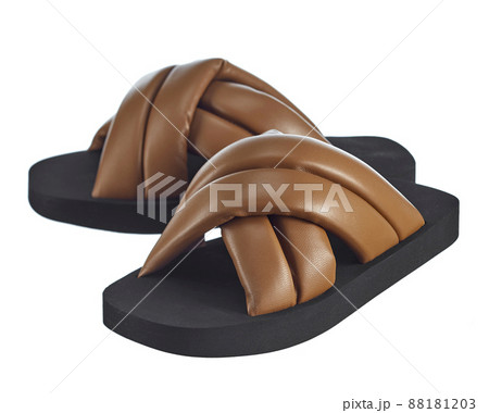 Pair of high-quality summer sandals made of brown leather straps criss-cross, on a polyurethane soft sole, isolated on a white background. Comfortable shoes for summer walks. Pair of high-quality summer sandals made of brown leather straps criss-cross, on a polyurethane soft sole, isolated on a white background. Comfortable shoes for summer walks. 88181203