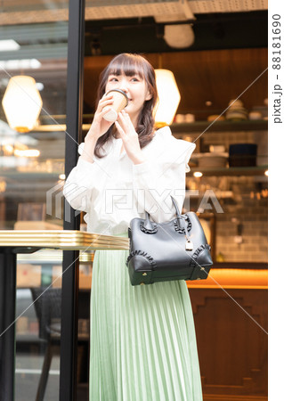 カフェからドリンクを持って出てきた若い女性 88181690