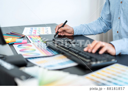 Young creative graphic designer working on color selection and drawing on graphics tablet at workplace, Color swatch samples chart for selection coloring 88181857