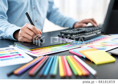 Young creative graphic designer working on color selection and drawing on graphics tablet at workplace, Color swatch samples chart for selection coloring Young creative graphic designer working on color selection and drawing on graphics tablet at workplace, Color swatch samples chart for selection coloring 88181859