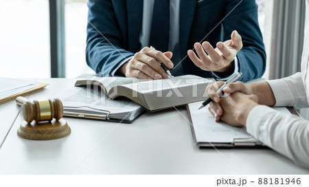 Male lawyer is pointing on legal document to explaining about consultation terms and condition to businesswoman before signing on contract at law firm 88181946
