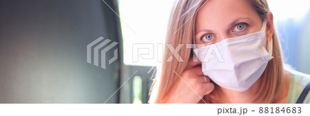 Portrait of young beautiful woman in protective mask on street 88184683