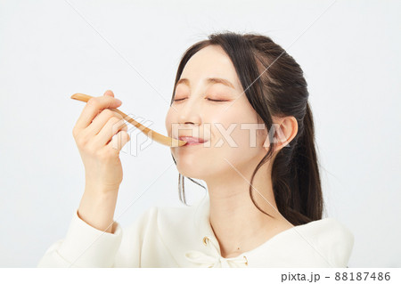 スプーンで食事をする女性 88187486