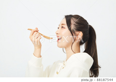 スプーンで食事をする女性 88187544