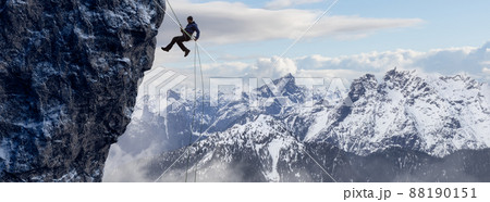 Adult adventurous man rappelling down a rocky cliff. Adult adventurous man rappelling down a rocky cliff. 88190151