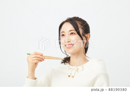 はしで食事をする女性 88190380