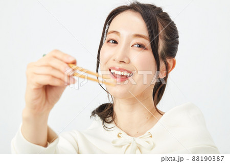はしで食事をする女性 88190387