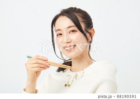 はしで食事をする女性 88190391
