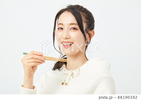 はしで食事をする女性 88190392