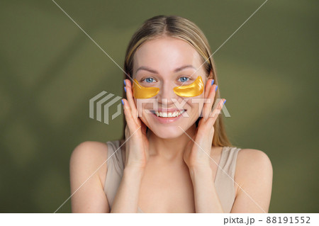 Close up of blonde caucasian girl face with natural no makeup look and white smile. Silicone under eye patches. Using skincare products from dark circles. Close up of blonde caucasian girl face with natural no makeup look and white smile. Silicone under eye patches. Using skincare products from dark circles. 88191552