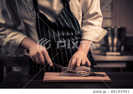 Chef cutting the fish on a board Chef cutting the fish on a board 88193401