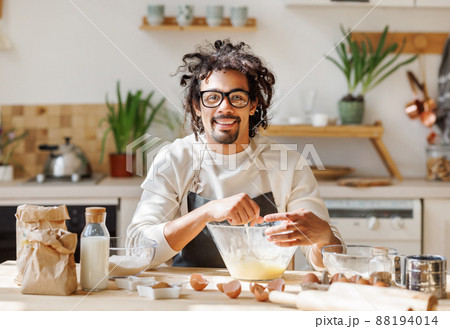 Black happy smiling man cooking pastry in kitchen 88194014