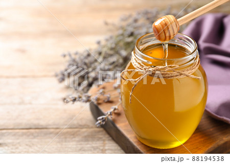 Tasty fresh sunflower honey with wooden dipper on table, closeup 88194538