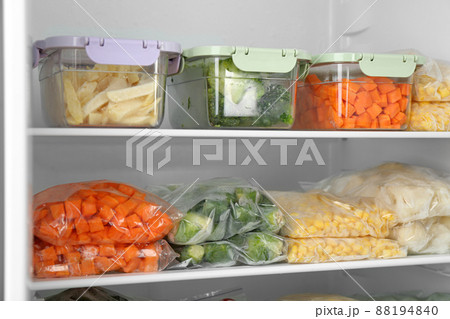 Plastic bags and containers with different frozen vegetables in refrigerator 88194840