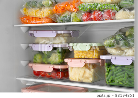 Plastic bags and containers with different frozen vegetables in refrigerator 88194851