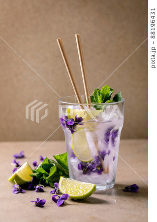 Glass of lemonade cocktail with violets flowers Glass of lemonade cocktail with violets flowers 88196431