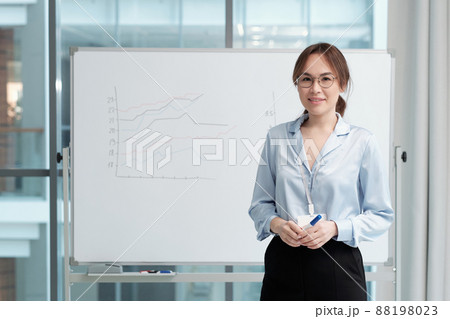 Young successful teacher of economics standing by whiteboard with graphs Young successful teacher of economics standing by whiteboard with graphs 88198023