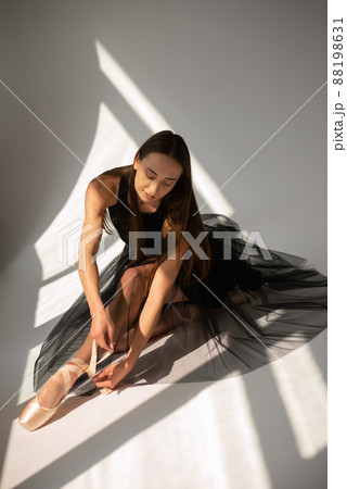 Ballerina ties the ribbons on ballet shoes. 88198631