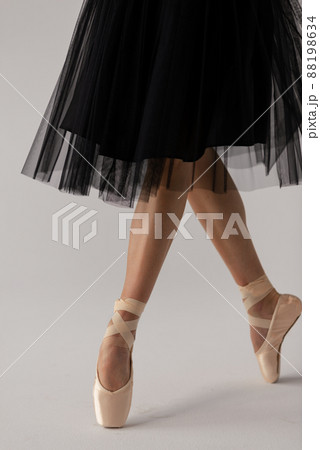 Crop of ballerina wearing black dress sitting on floor. Crop of ballerina wearing black dress sitting on floor. 88198634