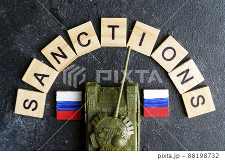 Sanctions against Russia concept. Toy tank and the inscription Sanctions on a dark background. War conflict in Ukraine, default, economic and monetary crisis in Russia. 88198732