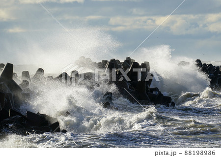 coastal storm in the baltic sea, big waves crash against the harbor breakwater 88198986