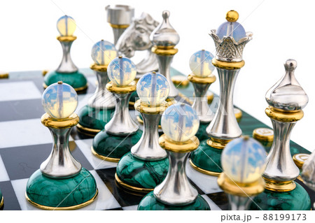 Malachite stone chess pieces on and marble chessboard 88199173